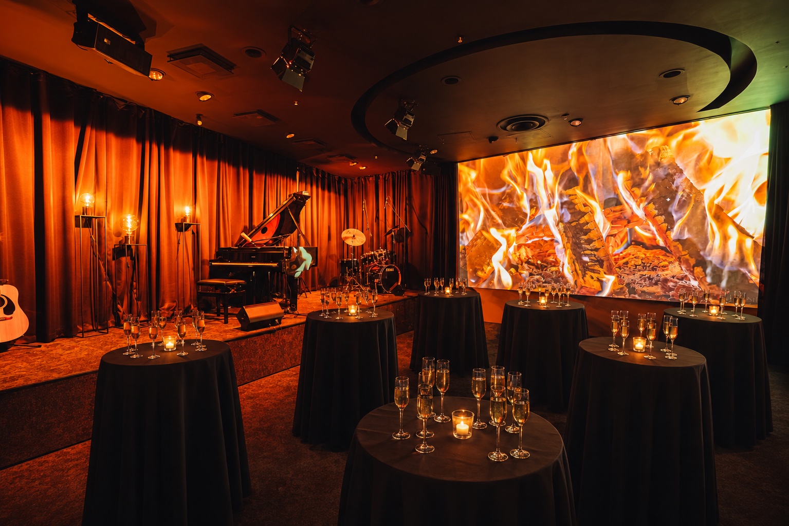 Downtown Piano Lab salė su paruoštais kokteilių staliukais, scena, koncertiniu fortepijonu ir didžiuoju ekranu