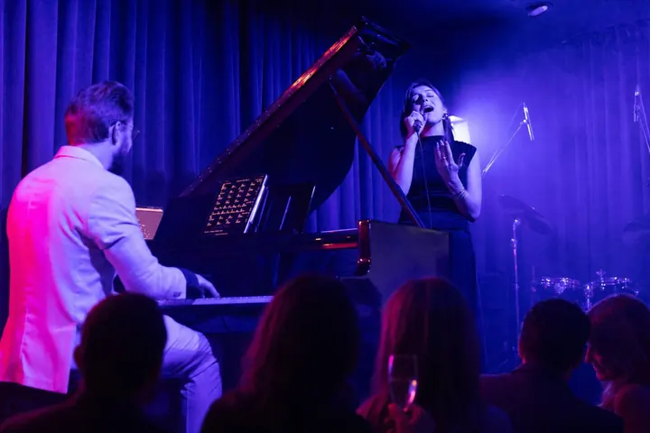 Pianistas ir vokalistė scenoje per privatų vakarą Downtown Piano Lab